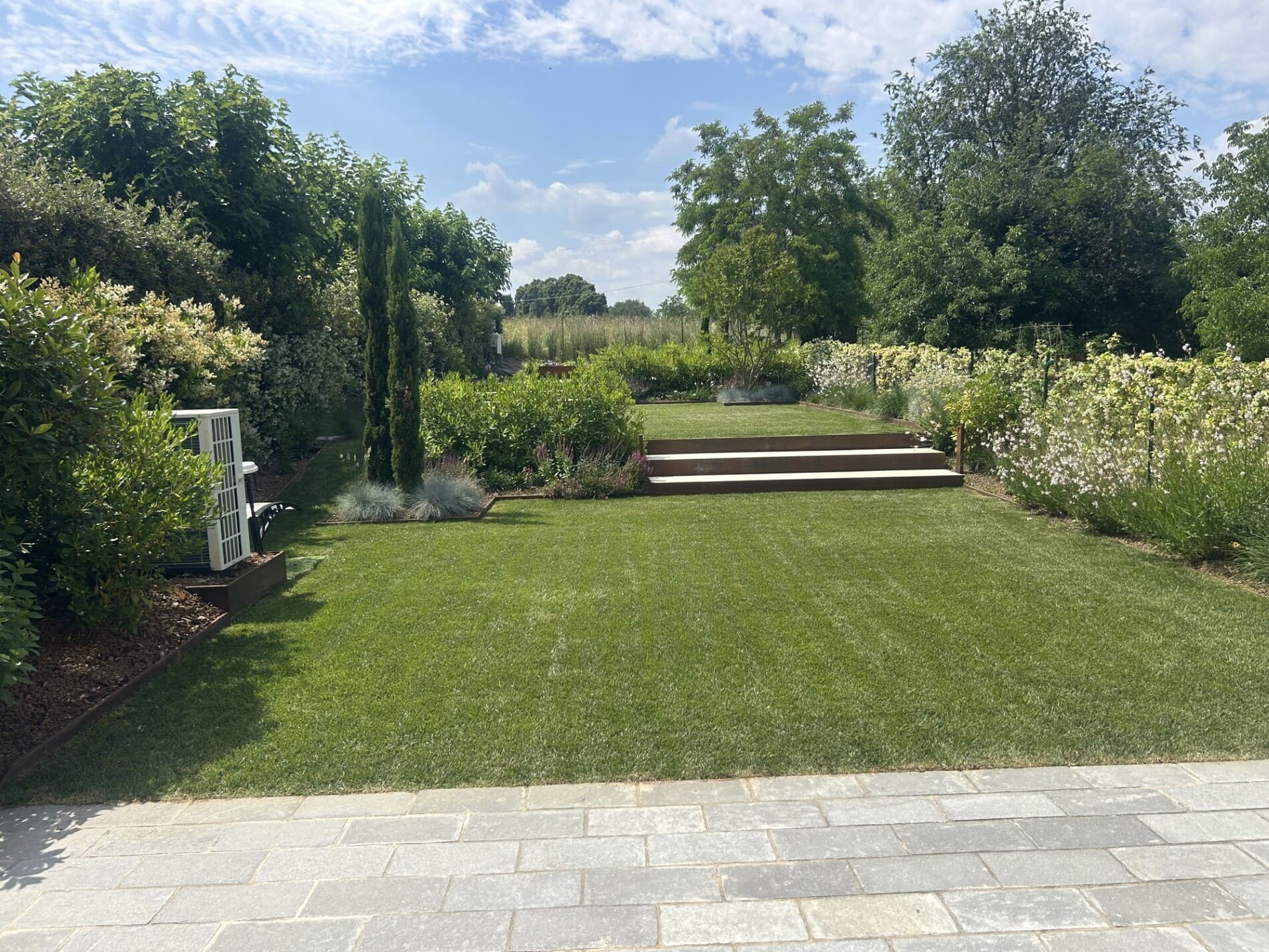 Giardino curato a Reggio Emilia, con prato verde e fioriture, ideale per servizi di giardinaggio professionale.